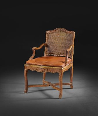 une chaise ancienne en bois avec une assise et des accoudoirs en cuir marron