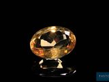 a close up of a yellow diamond on a black surface