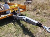 a machine that is attached to a trailer in the grass