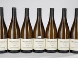 six bouteilles de vin sont alignées sur une table