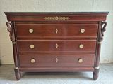 a wooden chest of drawers with brass hardware on top of it