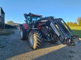 Le tracteur est garé devant la grange, sur le chemin de terre.