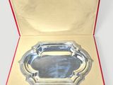 an open box with a silver tray inside of it on a white surface