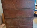 a wooden chest of drawers sitting on a tiled floor