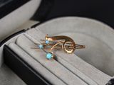 une bague en or sertie d'une turquoise, présentée dans un écrin