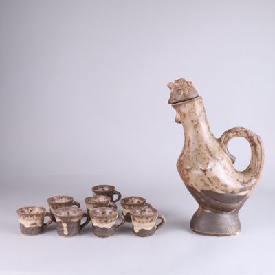 un vase et des tasses posés côte à côte sur une table
