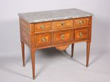 une petite commode à plateau en marbre posée sur un socle