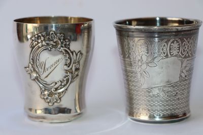 deux tasses en argent posées l'une à côté de l'autre sur une table