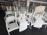 many white chairs and tables in a large room