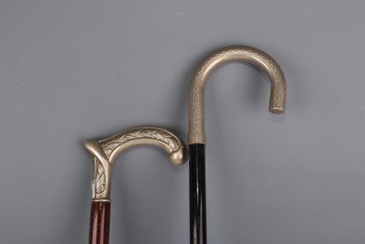 two old walking canes sitting next to each other on a gray surface