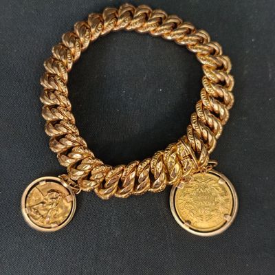un gros plan d'un bracelet en or orné de deux pièces