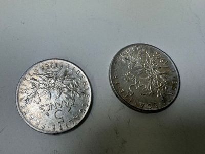 deux pièces d'argent posées l'une à côté de l'autre sur une table