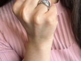 a woman wearing a pink shirt and a ring on her finger