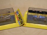 two model cars that are in a box on a table