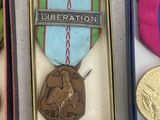 three medals and a medal are in a box on a table
