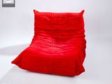un pouf rouge posé sur un sol blanc