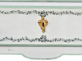 a white and green dresser with a gold decoration on it