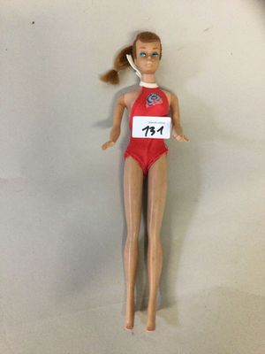 poupée Barbie portant un maillot de bain rouge avec une étiquette portant son nom