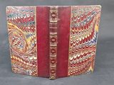 un vieux livre à la couverture rouge ornée de motifs dorés et bleus