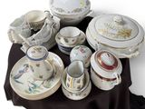 many different types of porcelain dishes and bowls on a table