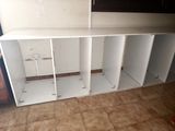 a room with a shelf and cabinets in it