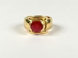 a close up of a gold ring with a red stone in it
