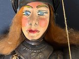 a statue of a woman wearing a helmet and holding a stick