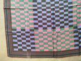 an image of a colorful checkered scarf hanging on a wall