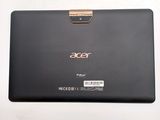 the back of a black laptop with a gold handle on a white surface
