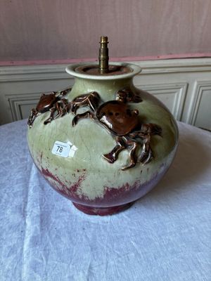 un vase vert orné de crabes, posé sur une table
