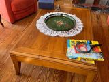 a coffee table in the middle of a living room with two chairs and a fire place
