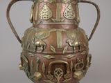 a large metal vase with a bird design on it