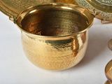 a gold cup sitting next to a silver plate