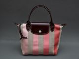 un sac à main rayé rose et beige avec une anse marron