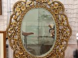un miroir au milieu d'une pièce où sont accrochés des tableaux aux murs