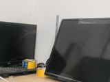 two computer monitors sitting on a desk next to each other