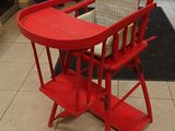a red high chair that is in the middle of a tiled floor