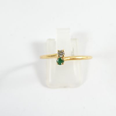 a close up of a gold ring with a green stone on it