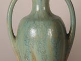 a green vase that is sitting on a table