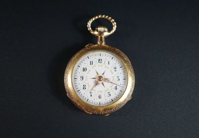 une montre de poche en or posée sur une surface noire