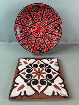 a red and black plate sitting on top of a coaster