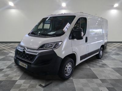 la camionnette blanche est garée dans une grande pièce au sol en damier