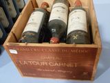 plusieurs bouteilles de vin se trouvent dans un coffret en bois sur une table