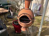 a clay pot sitting on top of a grill in the yard