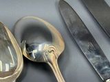 trois cuillères en argent et un couteau sur une table
