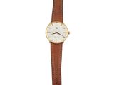 a close up of a watch on a white background with a brown strap