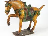 statue d'un cheval avec une selle sur le dos