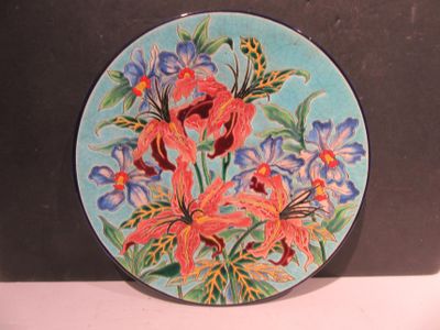 a plate with flowers painted on it sitting on a table