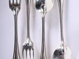 five spoons, two forks, and a spoon on a table