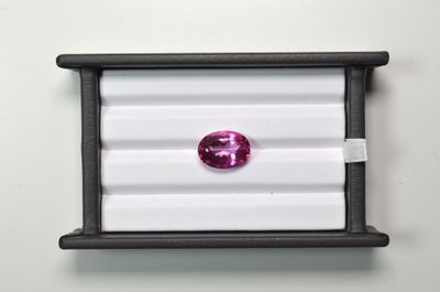 a close up of a pink diamond in a black box